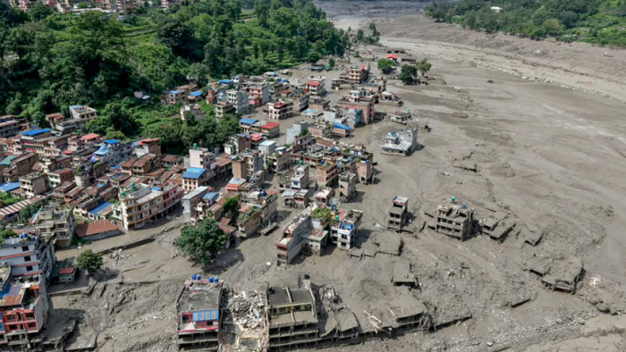 নেপালের নুয়াকোট জেলার ত্রিশুলি বাজারে বুধবার আকস্মিক বন্যায় নদীর তীরবর্তী বাড়িঘর কর্দমাক্ত পানিতে আংশিক ডুবে যায়। ছবি : এএফপি